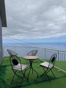 a table and two chairs on a balcony with the ocean at Sea View Pedra Mar in Campanário