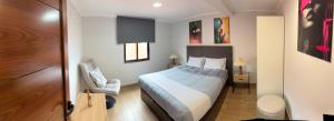 a bedroom with a bed and a chair in a room at Sea View Pedra Mar in Campanário
