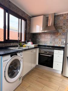a kitchen with a washing machine and a sink at Sea View Pedra Mar in Campanário