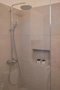 a shower with a glass door with three bottles at Villa Eleni Aegina in Egina +42 photos