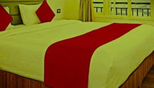 a red and white bed in a bedroom at The Nagpal Hotel in Haridwār