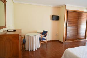 a room with a table and chairs and a bed at Hostal Guadiana in Ruidera
