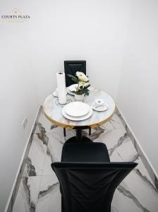 a small table with a bowl of flowers on it at Courts Plaza Apartments in Bawaleshi