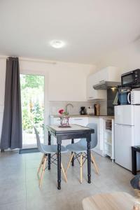 a kitchen with a table and two chairs in it at Détente à deux in Saint-Martin-de-Seignanx