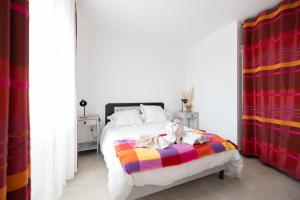 a bedroom with a bed with a colorful blanket at Détente à deux in Saint-Martin-de-Seignanx