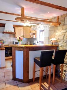 a kitchen with a counter and two chairs at a island at Ferienwohnung Zeittor in Tharandt +7 photos