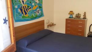シャッカにあるVilletta Nausicaのベッドルーム1室(ベッド1台付)が備わります。壁には絵画が飾られています。