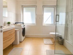 a bathroom with a toilet sink and a washing machine at 3-Zimmer-Wohnung mit Terrasse in zentraler Lage in Stuttgart +6 photos