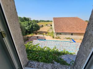 a view of a swimming pool from a window at Le Domaine de Champerou - Chambres d'hôtes in Cabariot