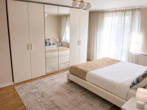 a bedroom with white cabinets and a large bed at 3-Zimmer-Wohnung mit Terrasse in zentraler Lage in Stuttgart