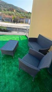 two chairs and a table on a patio with green grass at El Mar in Coldragone