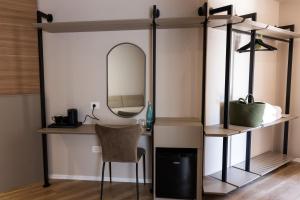 a dressing table with a mirror and a chair at KAÑ Inn in Vlorë