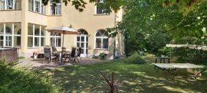 a garden with a table and chairs and an umbrella at Villa Panorama in Biatorbágy