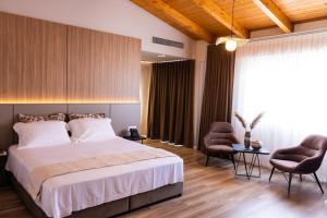 a bedroom with a large bed and two chairs at KAÑ Inn in Vlorë