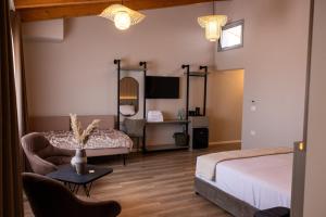 a bedroom with a bed and a couch and a table at KAÑ Inn in Vlorë