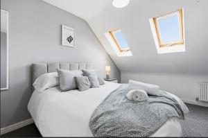 a bedroom with a white bed with a teddy bear on it at Home Comforts Await! 3bed 2.5bath in Ellesmere Port