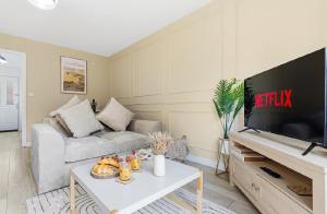 a living room with a couch and a flat screen tv at Home Comforts Await! 3bed 2.5bath in Ellesmere Port