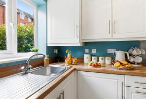 a kitchen with white cabinets and a sink at Home Comforts Await! 3bed 2.5bath in Ellesmere Port +12 photos