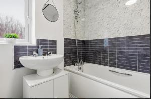 a bathroom with a sink and a toilet and a bath tub at Home Comforts Await! 3bed 2.5bath in Ellesmere Port