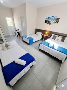 a hotel room with two beds in a room at Studio Cataratas com garagem e ar condicionado in Foz do Iguaçu