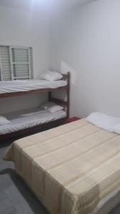 a room with two bunk beds and a bedskirts at Beach Hostel do Japa in Ubatuba