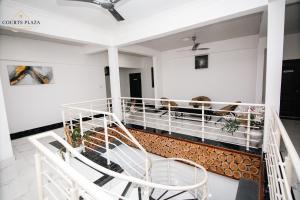 a balcony with two white chairs and a table at Courts Plaza Apartments in Bawaleshi