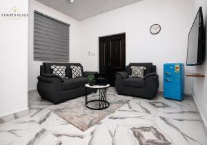 a living room with two couches and a table at Courts Plaza Apartments in Bawaleshi