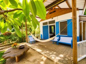 a hammock on the porch of a tiny house at Hotel Fuerte Mayal in Puerto Limón