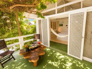 a porch with a table and chairs and a hammock at Hotel Fuerte Mayal in Puerto Limón