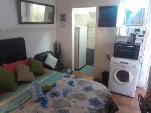 a living room with a bed and a microwave at Aires del Atlántico Sur in Burzaco