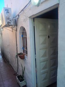 a white garage door with a window and a plant at Aires del Atlántico Sur in Burzaco