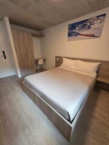 a bedroom with a large bed with white sheets at Regina by GoAcademy in Agno