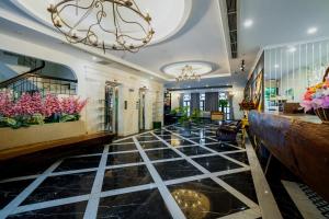 a lobby with a black tile floor and a chandelier at Le House Boutique Hotel - 100m to the beach in Danang +78 photos