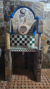 a stone oven with a checkered floor in a room at Dar chez bassou in Imilchil