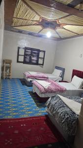 a room with four beds in a room with at Dar chez bassou in Imilchil