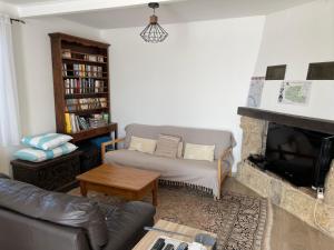 a living room with a couch and a fireplace at Le Grand Gîte in Pellegrue