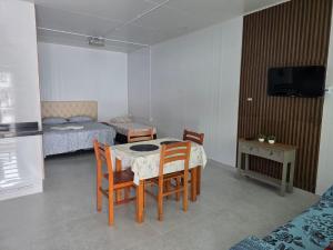 a room with a table and chairs and a bedroom at Pousada Rota do Sol Bombinhas Suítes e Flats - café da manhã servido de nov a páscoa in Bombinhas