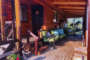 a porch of a log cabin with rocking chairs at Cozy Cabin Oxen-Le-Fields Montana in Conner