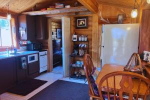 a kitchen with a refrigerator and a table in a cabin at Cozy Cabin Oxen-Le-Fields Montana in Conner