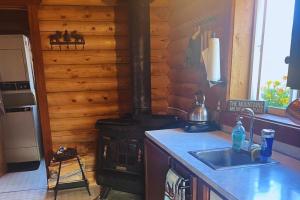 a kitchen with a stove and a sink in a cabin at Cozy Cabin Oxen-Le-Fields Montana in Conner +6 photos