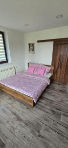 a bedroom with a large bed with pink pillows at Apartament WLA in Barcice