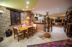 a dining room with a wooden table and a stone wall at Villa Concipat Rooms in Fonte Nuova