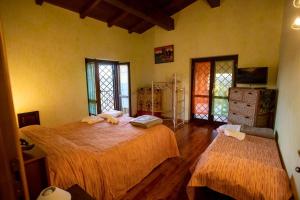 a bedroom with two beds and two windows at Villa Concipat Rooms in Fonte Nuova