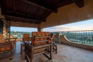 a porch with chairs and a balcony with a view at Villa Concipat Rooms in Fonte Nuova +18 photos