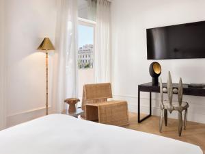 a bedroom with a bed and a desk and a window at ATHENA Pallas in Athens
