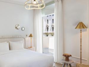 a bedroom with a white bed and a window at ATHENA Pallas in Athens