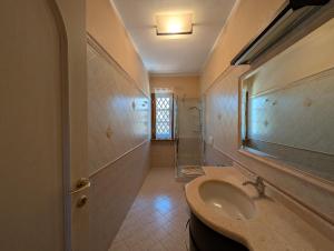 a bathroom with a sink and a mirror and a shower at La Piccola Atene Oasi in Strettoia +13 photos