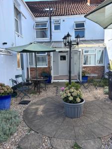 a patio with a table and an umbrella at Admiral Blake Guesthouse in Bridgwater