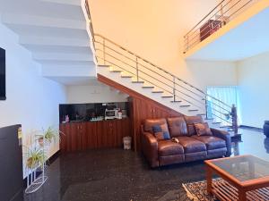 a living room with a couch and a staircase at Yelagiris Honey Stay in Yelagiri