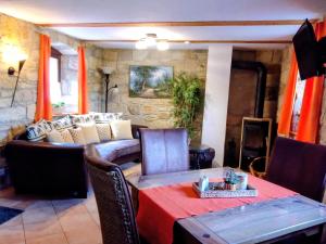 a dining room with a table and a couch at Ferienwohnung Zeittor in Tharandt